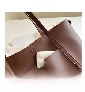 Detail view of brown soft leather tote bag showing adjustable strap and stitching
