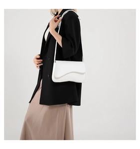 Bolso blanco de hombro con solapa ondulada llevado por modelo en estilo casual chic