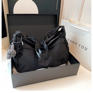 Detail van zwarte minimalistische tote bag in geschenkverpakking met schaakbordhanger