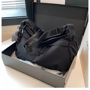 Detail van zwarte nylon shopper met schaakbordbedeltje in een luxe geschenkdoos