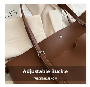 Detail of adjustable metal buckle and stitching on large brown PU leather tote bag