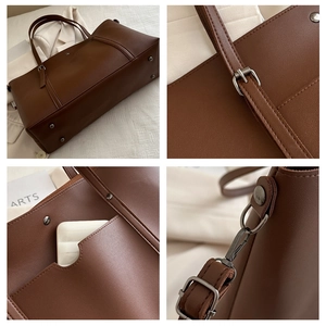 Detail view of dark brown leather tote showing silver rivets and adjustable strap