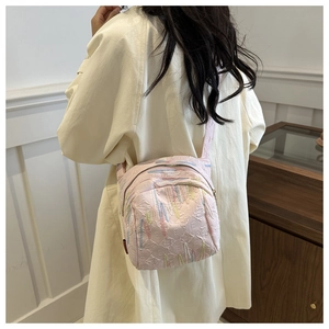 Vue détaillée d'un sac à dos rose matelassé avec broderie arc-en-ciel sur un modèle