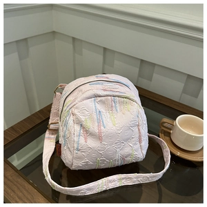 Détail du sac bandoulière matelassé rose avec broderie colorée et étiquette Fashion