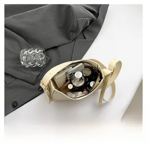 Top view showing spacious interior of the cream bucket bag with daily essentials