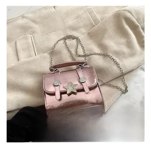 Dettaglio mini borsa quadrata oro rosa con trama metallica, fibbia a stella e catena