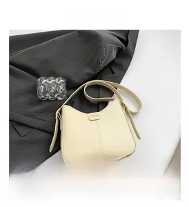 Detail view of cream bucket bag with gold 'FASHION' hardware on grey blazer