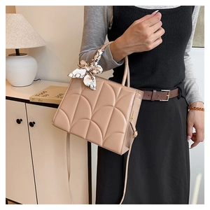 Détail du sac matelassé abricot avec poignée en foulard de soie et bandoulière