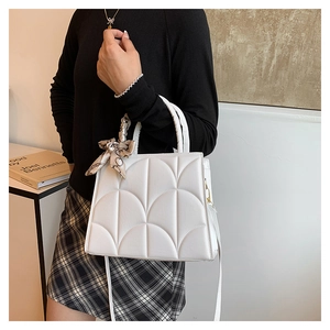 Détail du sac à bandoulière matelassé blanc avec foulard en soie autour de l'anse