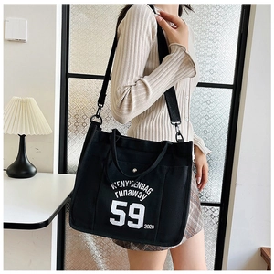 Detail of black canvas tote bag with 59 print, featuring detachable shoulder strap and handles