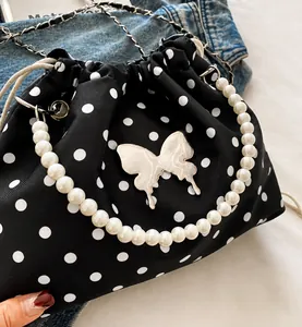Detail van de polkadot emmertas met parelhandvat en decoratief vlinderaccent