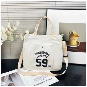 Detail of white canvas tote bag with black letter print and adjustable beige strap