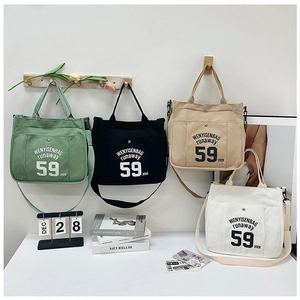 Detail of canvas tote bags in four colors with adjustable straps and letter print