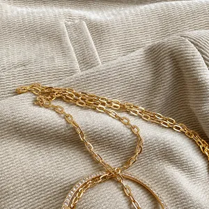 Close-up of gold chain necklace with a sparkling pavé diamond circle pendant detail
