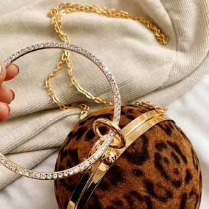 Close-up of leopard print round bag with rhinestone-encrusted gold ring handle
