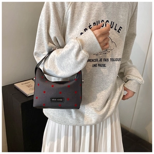 Détail du mini sac polochon gris à pois rouges avec logo Rich Rabbit en métal