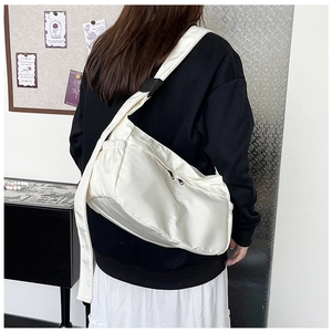 Detailansicht der weißen Nylon-Tasche mit schwarzem Reißverschluss und breitem Gurt