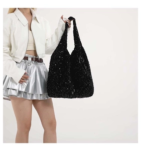 Dettaglio di una grande borsa tote con paillettes nere che mostra la trama scintillante