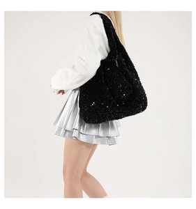 Dettaglio di una grande borsa tote con paillettes nere e riflessi luminosi