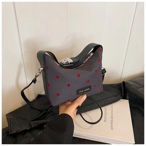 Détail du sac à main en tissu gris à pois rouges avec fermoir argenté par rich rabbit