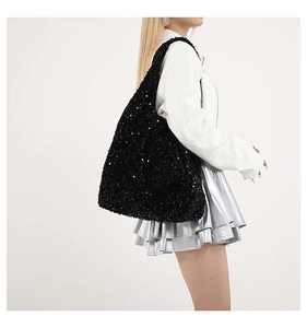 Dettaglio della borsa shopper con paillettes nere che mostra i riflessi di luce