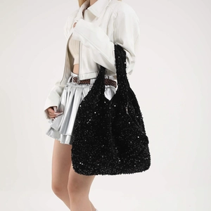 Grande borsa tote nera con paillettes minimalista indossata da modella su sfondo bianco