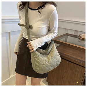 Detail view of heart-quilted olive green nylon tote bag with wide shoulder strap