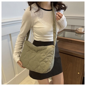 Détail d'un sac cabas vert sauge avec surpiqûres en cœur et large bandoulière