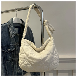 Détail du sac hobo blanc avec matelassage en cœur et bandoulière à nœuds élégante