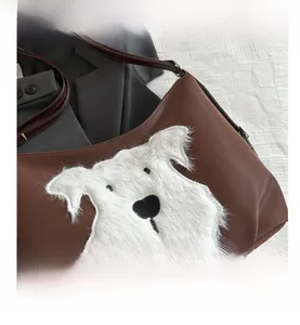 Close-up of a brown leather shoulder bag featuring a fuzzy white dog patch detail