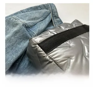 Detailaufnahme der silbernen Stepptasche mit schwarzen gewebten Trägern und V-Steppmuster