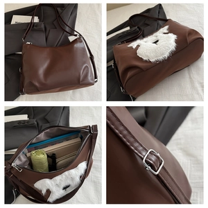 Detail view of coffee PU leather tote showing plush puppy patch and large inner capacity