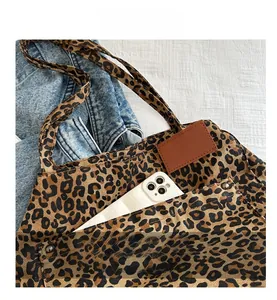 Detailed macro shot of leopard print canvas tote with leather patch and rivet accents
