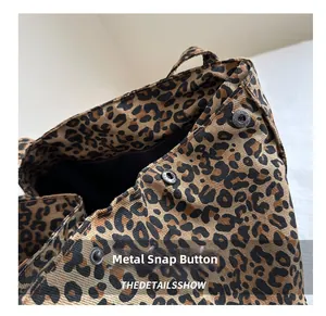 Detail of leopard print canvas tote bag featuring a durable magnetic snap metal fastener