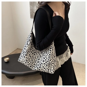 Gros plan du sac hobo à motif léopard noir et blanc avec bandoulière en cuir noir