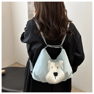 Detail of light blue crossbody bag featuring a cute white plush puppy patch on the back