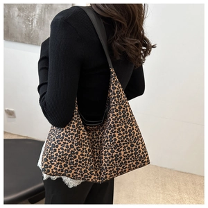 Vue de côté d'un grand sac cabas à imprimé léopard porté à l'épaule pour un style décontracté