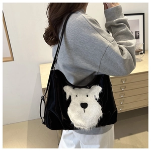 Detailed view of black high-gloss shoulder bag featuring a cute white plush puppy design