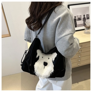 Close-up of black tote bag with white plush Schnauzer design and glossy finish