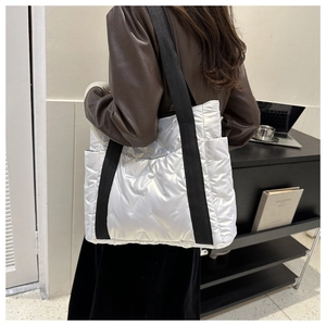Detailansicht der silbernen Stepptasche mit gepolsterter Textur und Seitentasche
