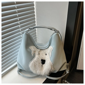 Detail of light blue shoulder bag with 3D white plush schnauzer dog patch and silver buckle