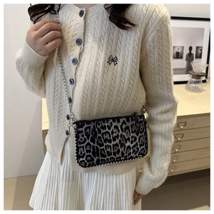 Sac à bandoulière léopard chic avec chaîne argentée porté par un mannequin en intérieur