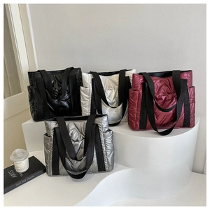 Close-up of quilted nylon tote bags in black, silver, white and burgundy with wide straps