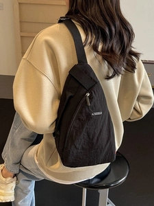 Sac à bandoulière minimaliste en nylon noir avec sangle réglable et poche zippée avant