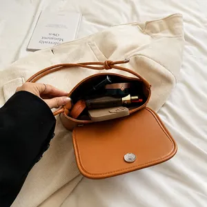 Brown leather crossbody bag showing large interior capacity for phone and cosmetics