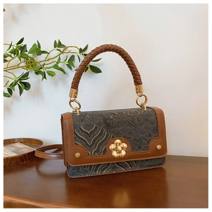 Close-up of vintage crossbody bag with gold floral clasp and brown woven handle