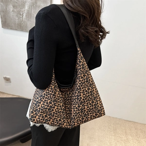 Sac fourre-tout hobo à motif léopard avec bandoulières noires porté par un modèle