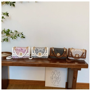 Detail of four retro small square bags with colorful patterns and golden floral clasps