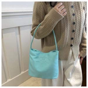 Détail du sac à bandoulière bleu clair avec broderie sur nylon au style minimaliste