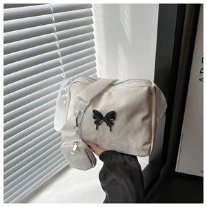Detail of beige nylon crossbody bag with butterfly logo and round coin purse attachment